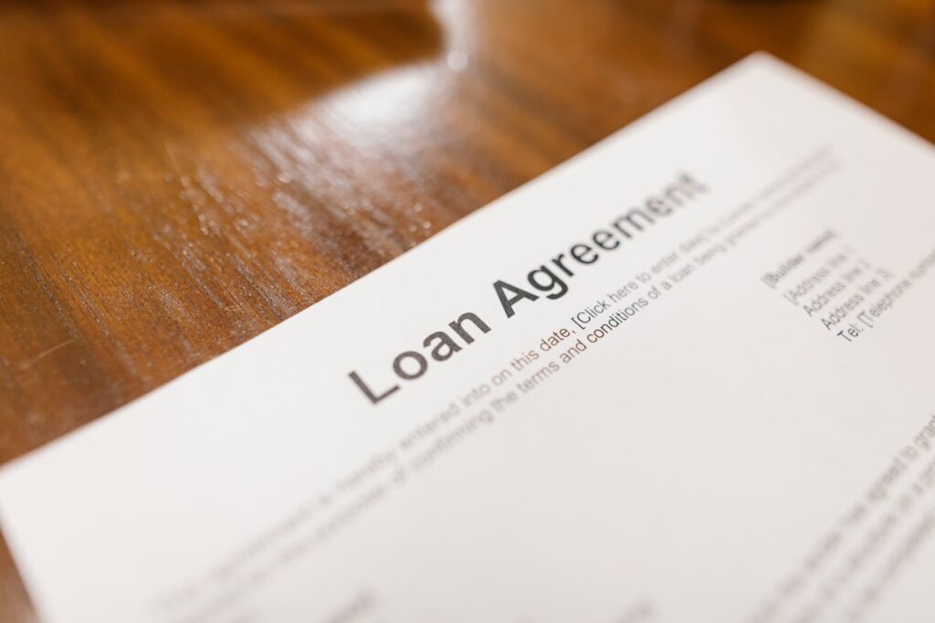 The Art of Drawing Readers In: Your attractive post title goes here Detailed loan agreement document close-up on a wooden table representing legal and financial concepts.